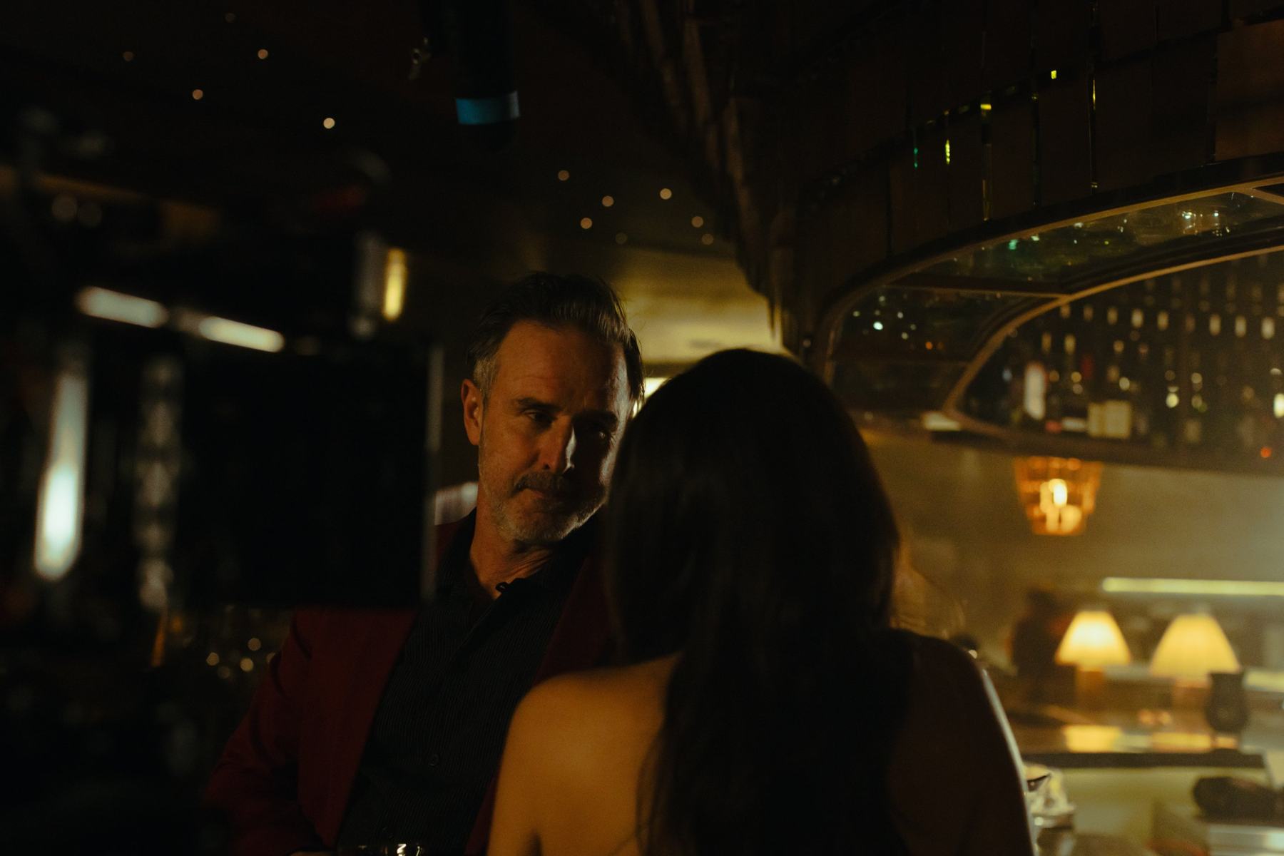 A tense conversation in a low-lit bar