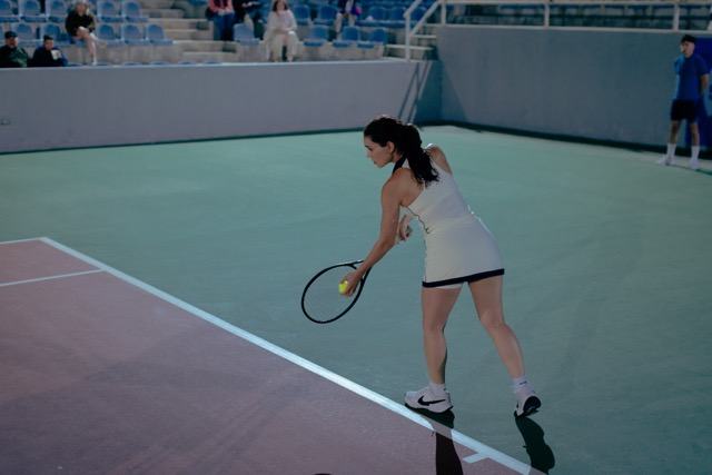 Isa serving on a hard court